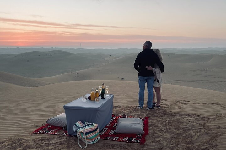 Witness the serenity of dawn over Dubai's dunes where wildlife roams freely and a private picnic invites you to savor the moment amidst breathtaking desert landscapes.